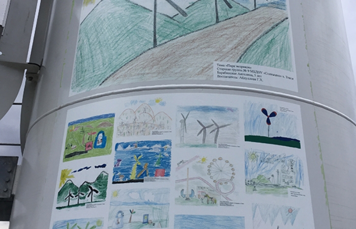 現地の子供たちによる絵画を風車タワーに貼り付けた